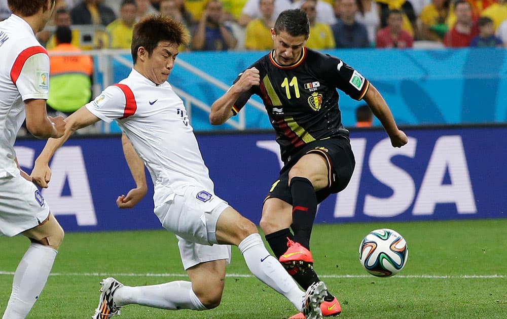 South Korea's Yun Suk-young, left, blocks a shot by Belgium's Kevin Mirallas during the group H World Cup soccer match between South Korea and Belgium at the Itaquerao Stadium in Sao Paulo, Brazil.