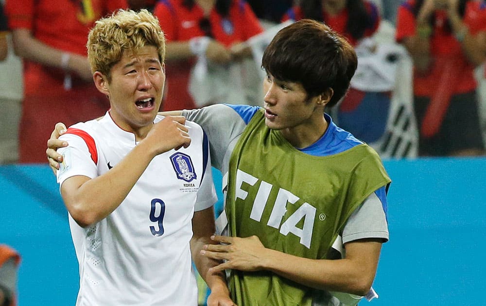 South Korea's Son Heung-min, is comforted by his teammate Han Kook-young, right, after the group H World Cup soccer match between South Korea and Belgium at the Itaquerao Stadium in Sao Paulo, Brazil. Belgium beat South Korea 1-0 to top Group H of World Cup.