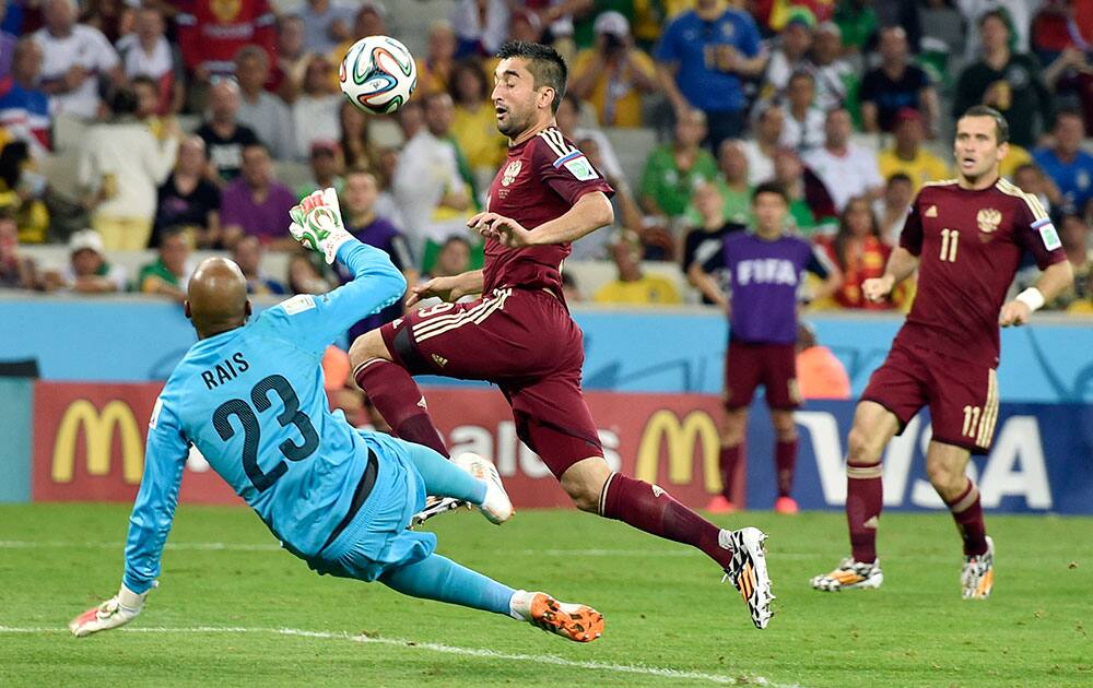 Algeria's goalkeeper Rais M’Bolhi makes a save from Russia's Alexander Samedov during the group H World Cup soccer match between Algeria and Russia at the Arena da Baixada in Curitiba, Brazil.