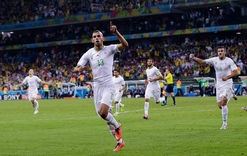 Algeria's Islam Slimani (13) celebrates after scoring during the group H World Cup soccer match between Algeria and Russia at the Arena da Baixada in Curitiba, Brazil.