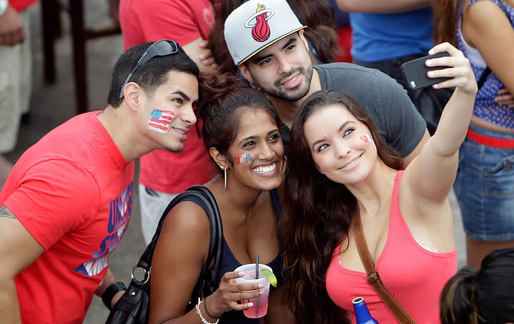 Soccer fans taking selfies while gathered at Lucky's Pub to view the United States World Cup soccer game against Germany, in Houston. 