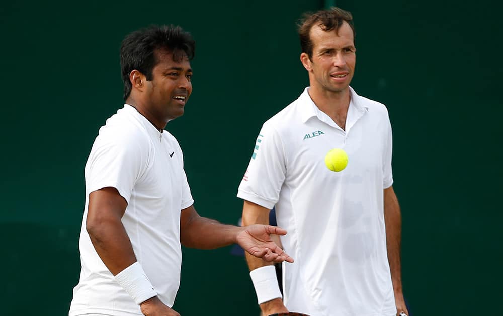 Laender Paes of India and Radek Stepanek of the Czech Republic talk between points during their men's doubles match against Mariusz Fyrstenberg of Poland and Rajeev Ram of the U.S. at the All England Lawn Tennis Championships in Wimbledon, London.