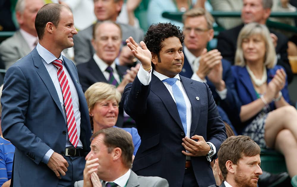 Sachin Tendulkar waves with England cricketer Andrew Strauss from the Royal Box on centre court at the All England Lawn Tennis Championships in Wimbledon, London.