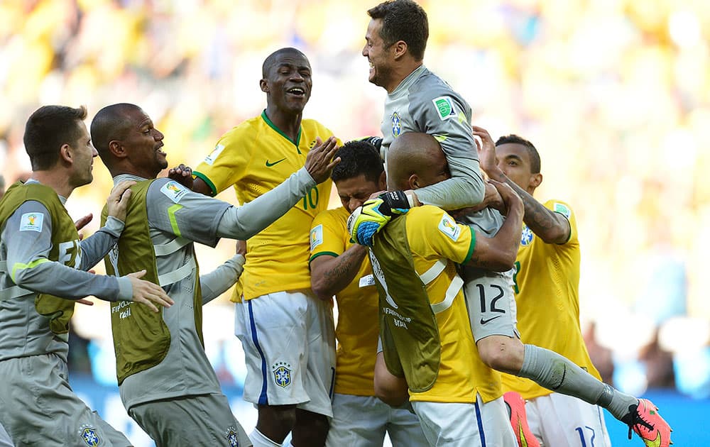 Brazil's goalkeeper Julio Cesar (12) celebrates with his teammates following regulation time during the World Cup round of 16 soccer match between Brazil and Chile at the Mineirao Stadium in Belo Horizonte, Brazil.