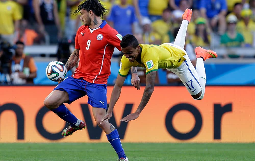 Chile's Mauricio Pinilla, left, and Brazil's Luiz Gustavo battle for the ball during the World Cup round of 16 soccer match between Brazil and Chile at the Mineirao Stadium in Belo Horizonte, Brazil.