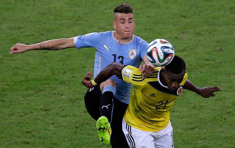 Uruguay's Jose Maria Gimenez, left, and Colombia's Jackson Martinez challenge for then all during the World Cup round of 16 soccer match between Colombia and Uruguay at the Maracana Stadium in Rio de Janeiro, Brazil.