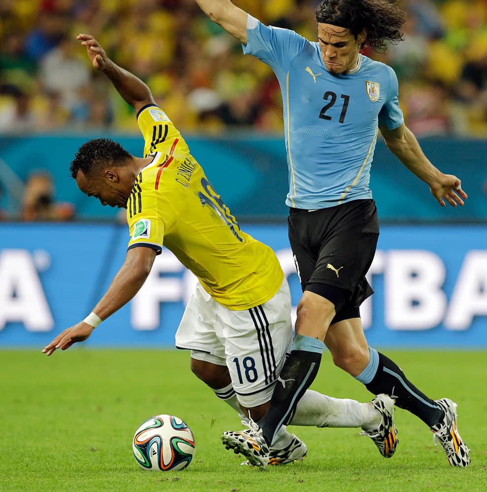 Uruguay's Edinson Cavani (21) tackles Colombia's Juan Zuniga during the World Cup round of 16 soccer match between Colombia and Uruguay at the Maracana Stadium in Rio de Janeiro, Brazil.