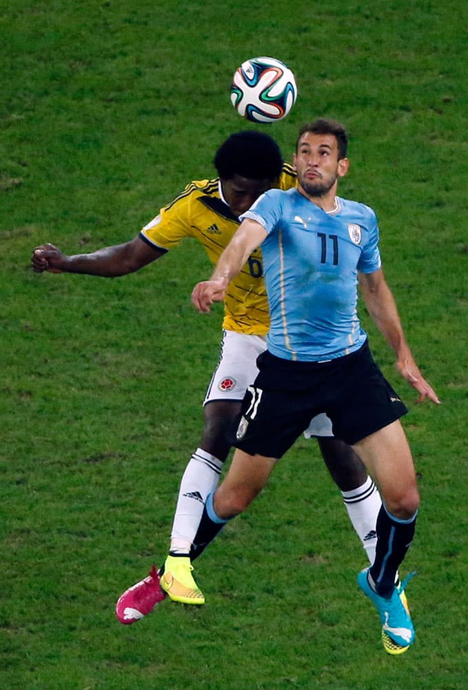 Colombia's Carlos Sanchez Moreno, left, and Uruguay's Christian Stuani go for a header during the World Cup round of 16 soccer match between Colombia and Uruguay at the Maracana Stadium in Rio de Janeiro, Brazil.