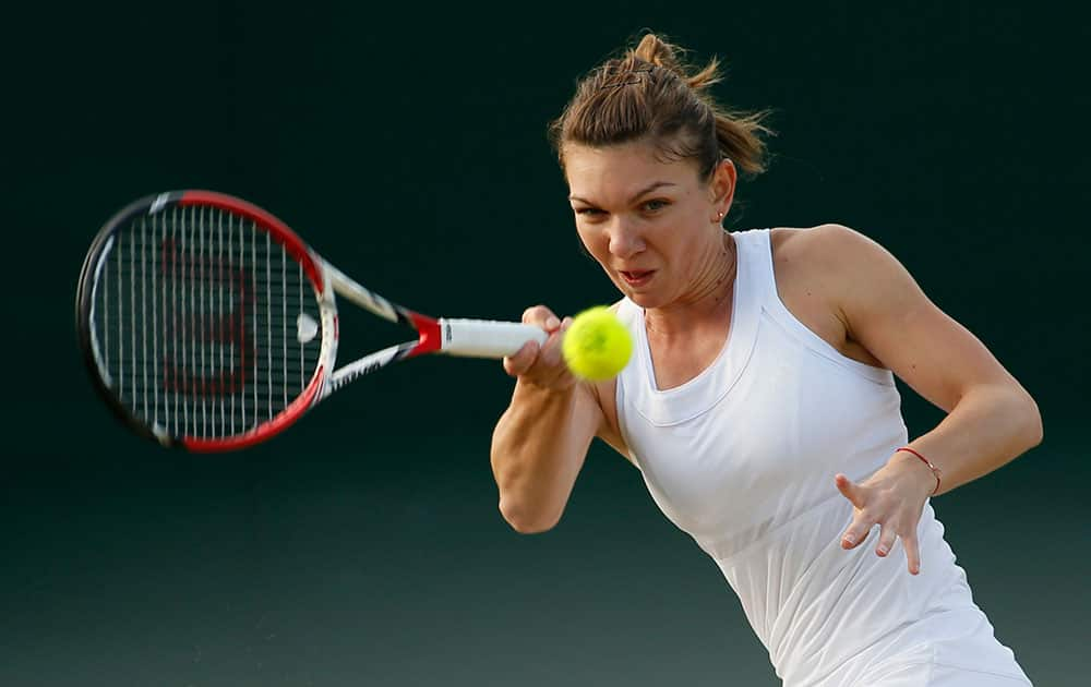 Simona Halep of Romania plays a return to Belinda Bencic of Switzerland during their women's singles match at the All England Lawn Tennis Championships in Wimbledon, London.