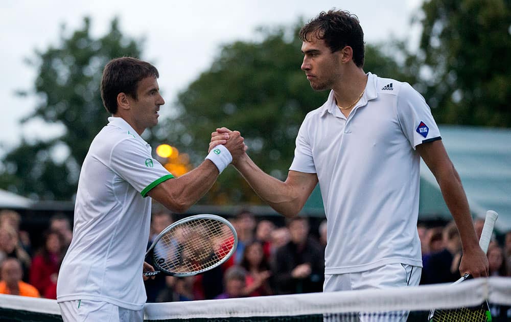 Tommy Robredo, left, of Spain shakes hands with Jerzy Janowicz of Poland after he defeated him in their men's singles match at the All England Lawn Tennis Championships in Wimbledon, London.