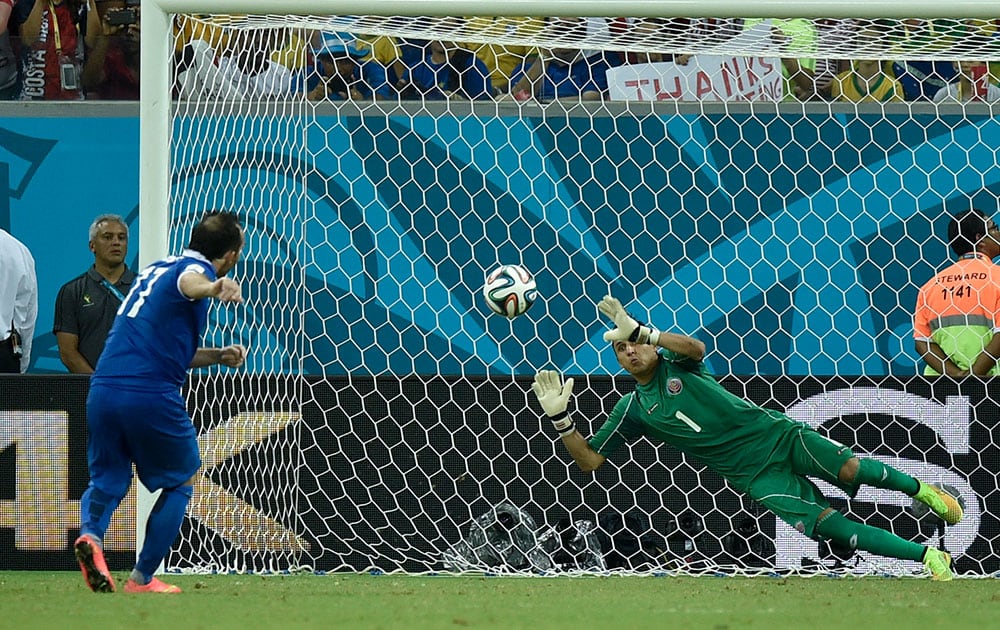 Costa Rica's goalkeeper Keylor Navas, right, makes a save on Greece's Fanis Gekas' penalty shot during a shootout after regulation time in the World Cup round of 16 soccer match between Costa Rica and Greece at the Arena Pernambuco in Recife, Brazil. Costa Rica defeated Greece