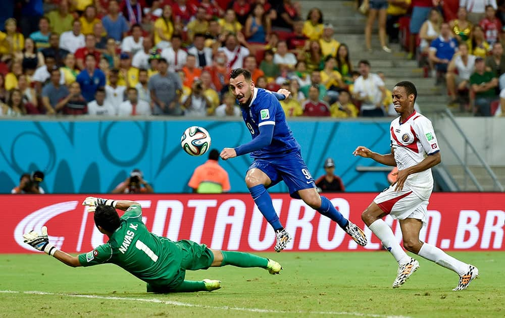 Costa Rica's goalkeeper Keylor Navas, left, makes a save on a shot by Greece's Kostas Mitroglou during extra time in the World Cup round of 16 soccer match between Costa Rica and Greece at the Arena Pernambuco in Recife, Brazil.