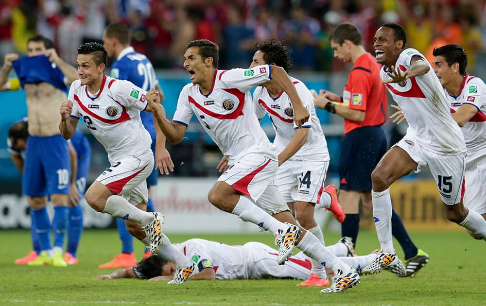 Costa Rica players react after Michael Umana scored during a shootout after regulation time in the World Cup round of 16 soccer match between Costa Rica and Greece at the Arena Pernambuco in Recife, Brazil.