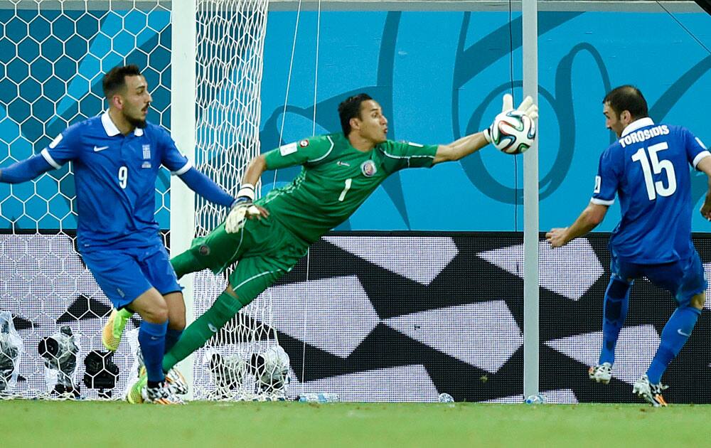 Costa Rica's goalkeeper Keylor Navas clears the ball away from Greece's Kostas Mitroglou (9) and Vasilis Torosidis during the World Cup round of 16 soccer match between Costa Rica and Greece at the Arena Pernambuco in Recife, Brazil.