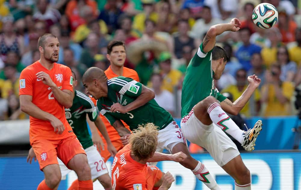 Netherlands' Dirk Kuyt, down, fights for the ball with Mexico's defenders during the World Cup round of 16 soccer match between the Netherlands and Mexico at the Arena Castelao in Fortaleza, Brazil.