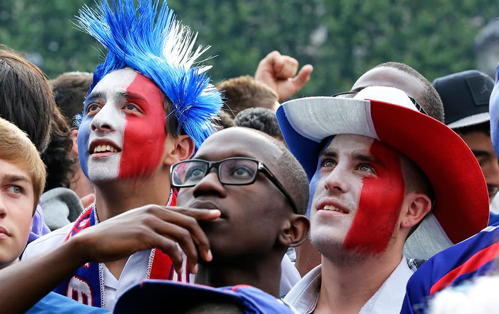 French soccer fans react as they watch the World Cup soccer match between France and Nigeria being shown live on a giant screen, in front of Paris City Hall.