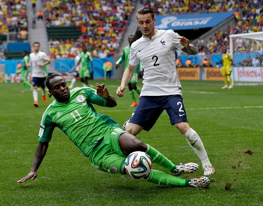 France's Mathieu Debuchy, right, and Nigeria's Victor Moses fight for the ball during the World Cup round of 16 soccer match between France and Nigeria at the Estadio Nacional in Brasilia, Brazil.