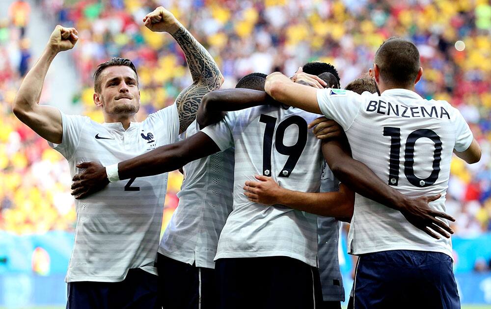 France's Paul Pogba (19) celebrates with teammates after scoring his side's opening goal during the World Cup round of 16 soccer match between France and Nigeria at the Estadio Nacional in Brasilia, Brazil.