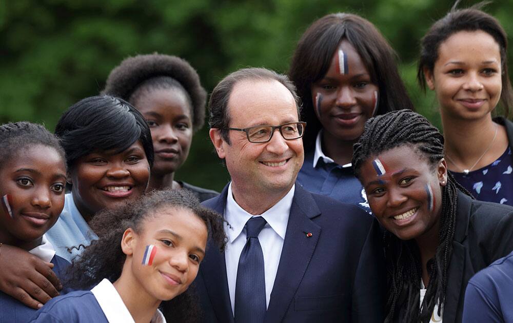 French President Francois Hollande, center, poses with young French soccer players, before watching the match between France and Nigeria, at the Elysee Palace in Paris.