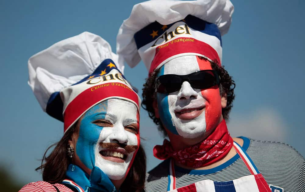 France soccer fans, with their faces painted with their team's colors arrive at the National Stadium to watch World Cup round of 16 match against Nigeria, in Brasilia, Brazil.