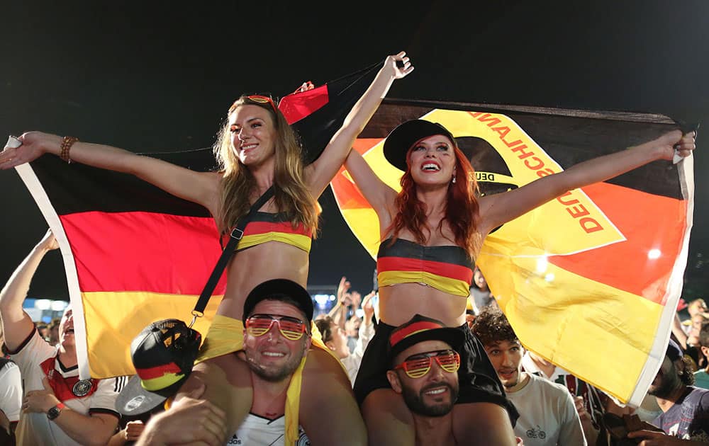 Germany soccer fans celebrate their team's victory over Algeria after watching the World Cup round of 16 match on a live telecast inside the FIFA Fan Fest area on Copacabana beach in Rio de Janeiro, Brazil.