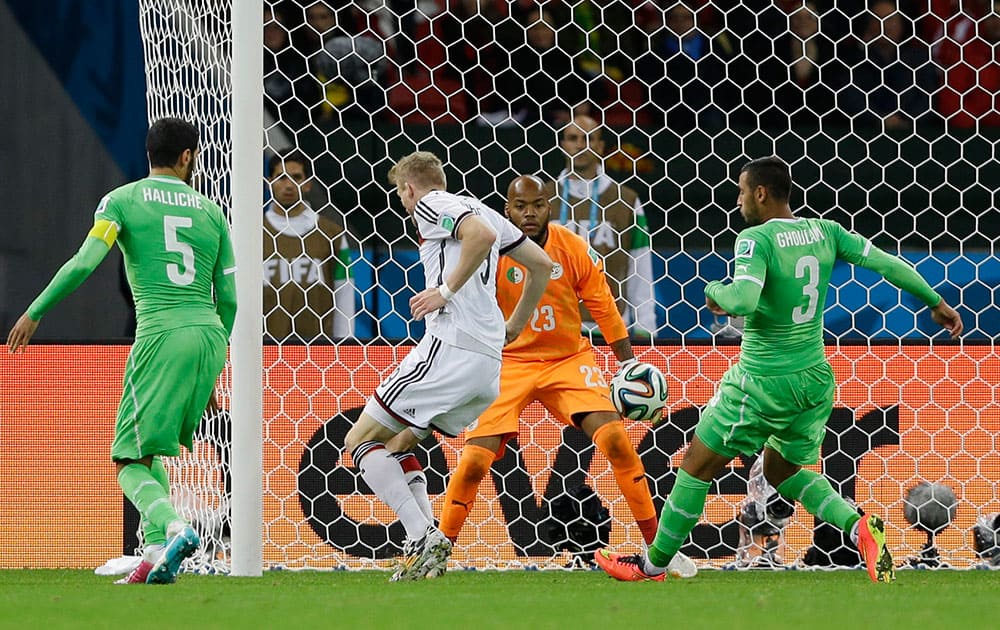 Germany's Andre Schuerrle scores his side's first goal against Algeria's goalkeeper Rais M’Bolhi during the World Cup round of 16 soccer match between Germany and Algeria at the Estadio Beira-Rio in Porto Alegre, Brazil.