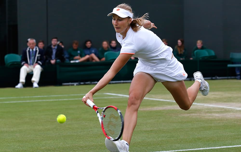 Ekaterina Makarova of Russia plays a return to Agnieszka Radwanska of Poland during their women's singles match at the All England Lawn Tennis Championships in Wimbledon.