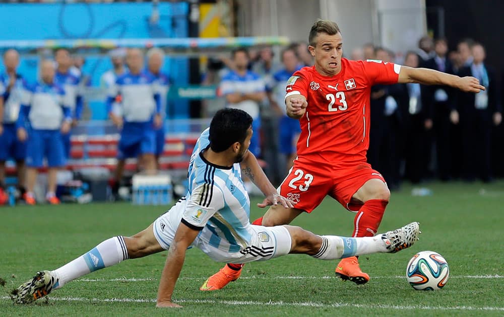 Switzerland's Xherdan Shaqiri is challenged during the World Cup round of 16 soccer match between Argentina and Switzerland at the Itaquerao Stadium in Sao Paulo, Brazil.