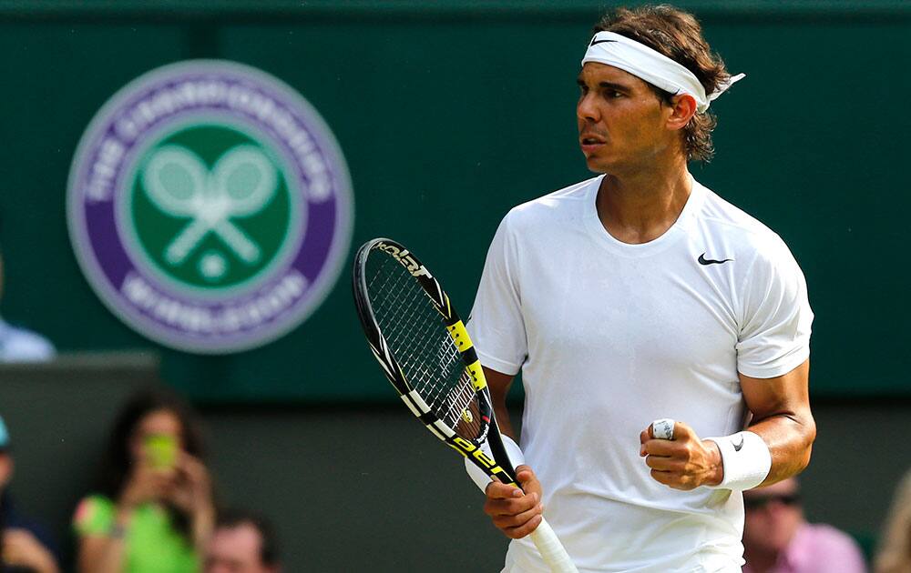 Rafael Nadal of Spain turns towards his coaches as he celebrates winning a point against Nick Kyrgios of Australia during their men's singles match on Centre Court at the All England Lawn Tennis Championships in Wimbledon.