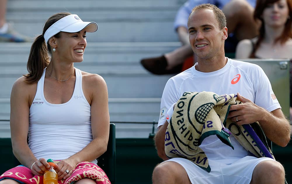 Martina Hingis of Switzerland, left, talks to playing partner Bruno Soares of Brazil during a game break in their mixed doubles match against Nicholas Monroe of the US and Shuai Zhang of China at the All England Lawn Tennis Championships in Wimbledon.