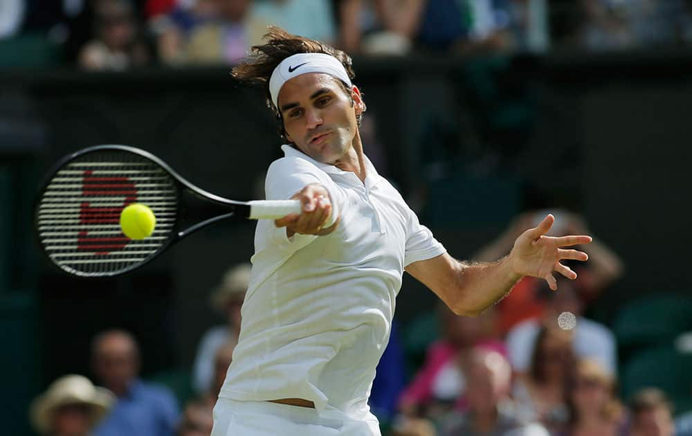 Roger Federer of Switzerland plays a return to Stan Wawrinka of Switzerland during their men's singles quarterfinal match at the All England Lawn Tennis Championships in Wimbledon.