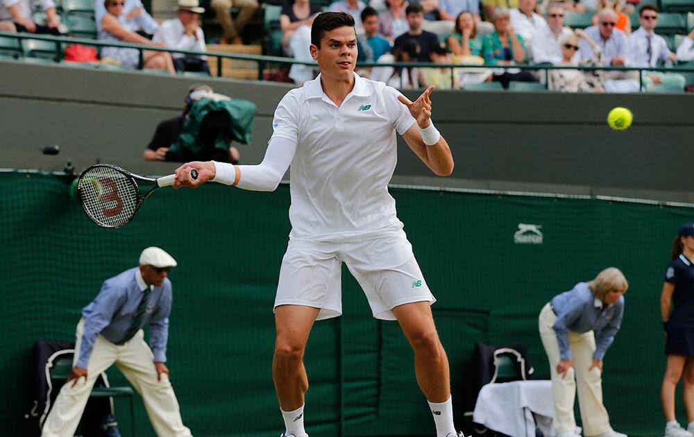 Milos Raonic of Canada plays a return to Nick Kyrgios of Australia during their men's singles quarterfinal match at the All England Lawn Tennis Championships in Wimbledon.