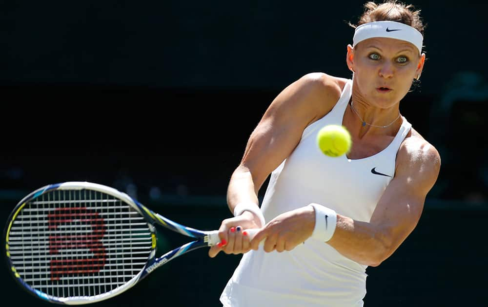 Lucie Safarova of Czech Republic plays a return to Petra Kvitova of Czech Republic during their women’s singles semifinal match at the All England Lawn Tennis Championships in Wimbledon.