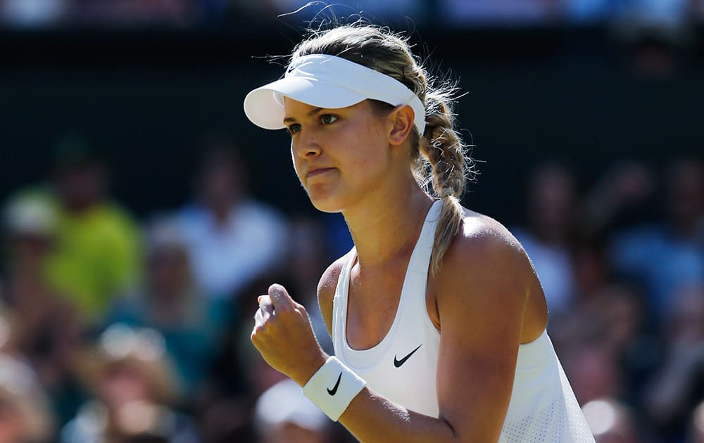 Eugenie Bouchard of Canada celebrates after winning the first set as she plays against Simona Halep of Romania during their women’s singles semifinal match at the All England Lawn Tennis Championships in Wimbledon, London.