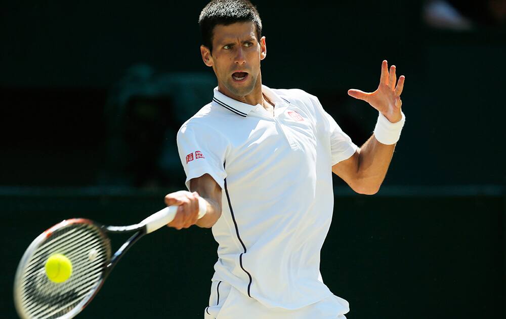 Novak Djokovic of Serbia plays a return to Grigor Dimitrov of Bulgaria during their men’s singles semifinal match at the All England Lawn Tennis Championships in Wimbledon, London.