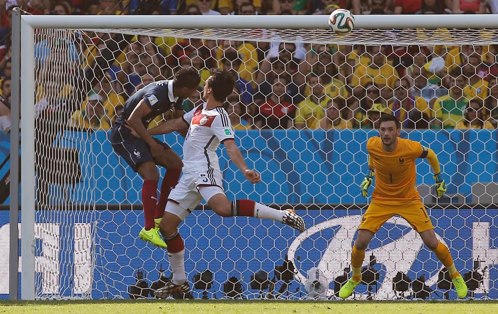 Germany's Mats Hummels, center, scores the opening goal during the World Cup quarterfinal soccer match between Germany and France at the Maracana Stadium in Rio de Janeiro, Brazil.