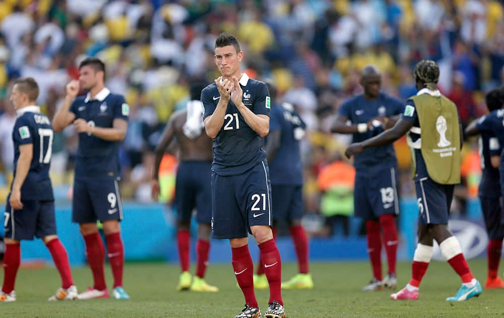 France's Laurent Koscielny, center, reacts at the end of the World Cup quarterfinal soccer match between Germany and France at the Maracana Stadium in Rio de Janeiro, Brazil.