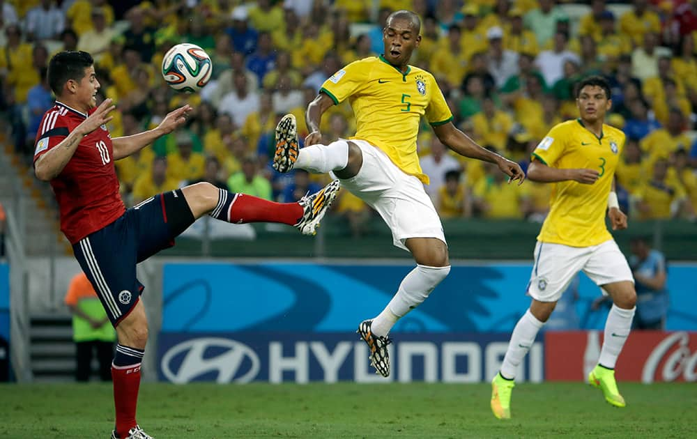 Colombia's James Rodriguez, left, and Brazil's Fernandinho challenge for the ball during the World Cup quarterfinal soccer match between Brazil and Colombia at the Arena Castelao in Fortaleza, Brazil