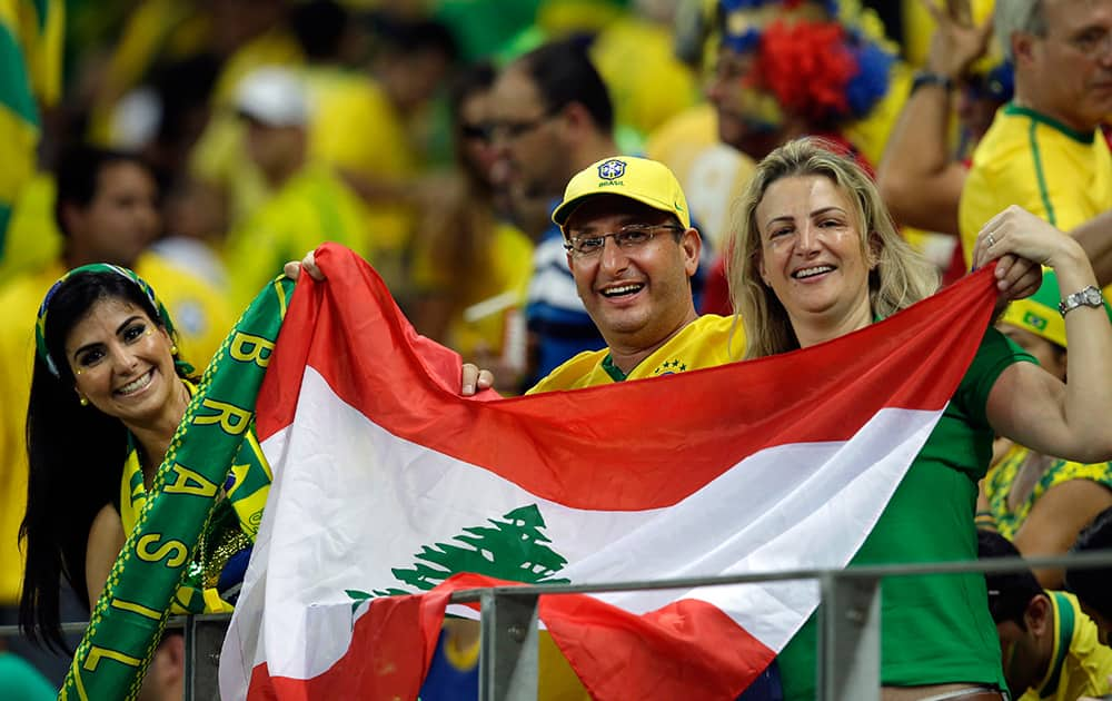 Fans hold a Lebanese flag during the World Cup quarterfinal soccer match between Brazil and Colombia at the Arena Castelao in Fortaleza, Brazil.