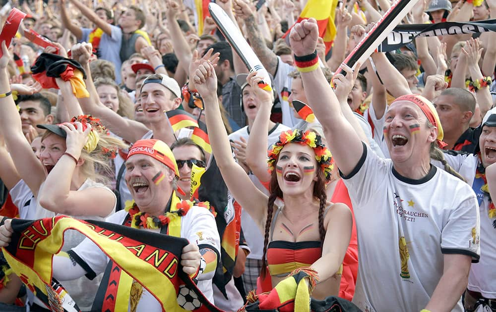 German soccer fans celebrate as they watch the Brazil World Cup quarter final soccer match between Germany and France at a public viewing event in Berlin.