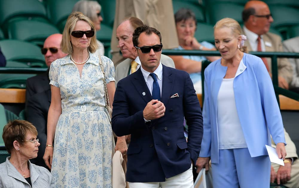 British actor Jude Law, center, walks back into the Royal Box to watch Roger Federer of Switzerland play against Milos Raonic of Canada in their men’s singles semifinal match at the All England Lawn Tennis Championships in Wimbledon.