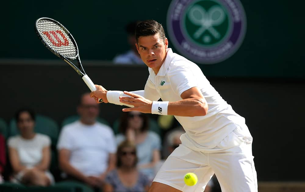 Milos Raonic of Canada plays a return to Roger Federer of Switzerland during their men’s singles semifinal match at the All England Lawn Tennis Championships in Wimbledon.