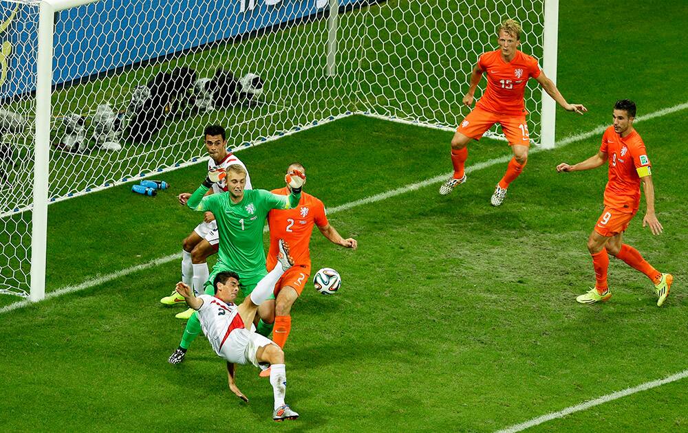 Costa Rica's Johnny Acosta, bottom left, kicks the ball during the World Cup quarterfinal soccer match between the Netherlands and Costa Rica at the Arena Fonte Nova in Salvador, Brazil.