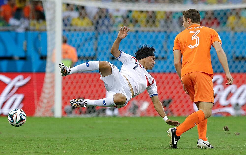 Costa Rica's Christian Bolanos, left, goes airborne after a challenge by Netherlands' Stefan de Vrij during the World Cup quarterfinal soccer match between the Netherlands and Costa Rica at the Arena Fonte Nova in Salvador, Brazil.