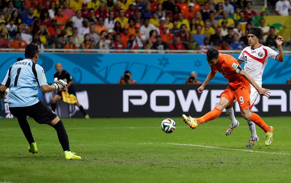 Netherlands' Robin van Persie takes a shot on Costa Rica's goalkeeper Keylor Navas while being defended by Christian Bolanos during the World Cup quarterfinal soccer match at the Arena Fonte Nova in Salvador, Brazil.