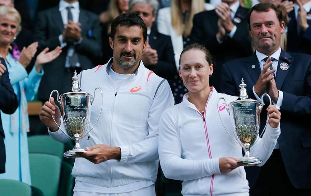 Nenad Zimonjic of Serbia and Samantha Stosur of Australia hold their trophies after defeating Max Mirnyi of Belarus and Hao-Ching Chan of Taiwan in the mixed doubles final at the All England Lawn Tennis Championships in Wimbledon.