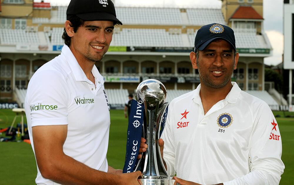 Alastair Cook and M.S. Dhoni pose with the Trophy during a photocall ahead of the first Test Match between England and India at Trent Bridge cricket ground, Nottingham, England.