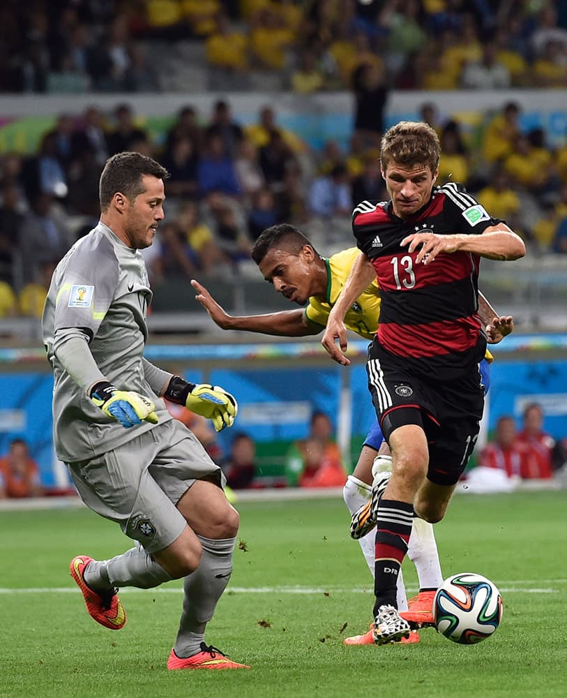 Germany's Thomas Mueller, right, tries to take the ball round Brazil's goalkeeper Julio Cesar during the World Cup semifinal soccer match between Brazil and Germany at the Mineirao Stadium in Belo Horizonte, Brazil.