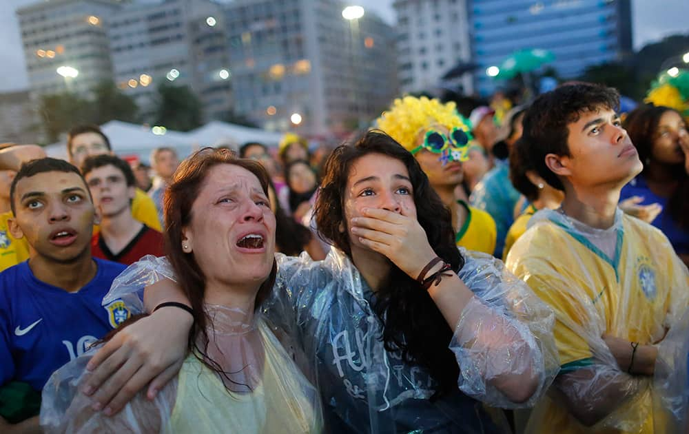 Brazil soccer fans cry as they watch their team lose 7-1 to Germany at a World Cup semifinal match on a live telecast inside the FIFA Fan Fest area on Copacabana beach in Rio de Janeiro, Brazil.