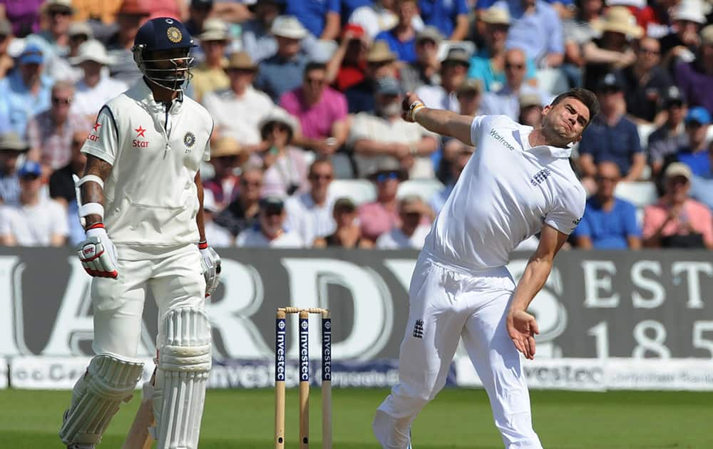 England's James Anderson, right, bowls watched by India's Shikhar Dhawan during day one of the first Test between England and India at Trent Bridge cricket ground, Nottingham.